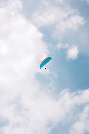 Faceless people paragliding in blue sky