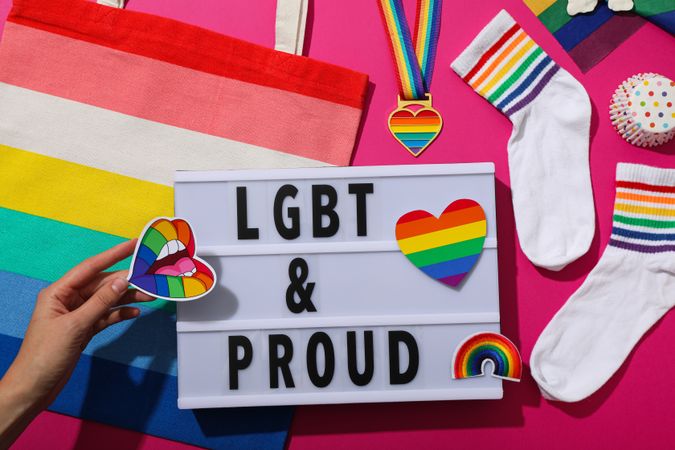 LGBT parade concept, holiday symbols on pink background.