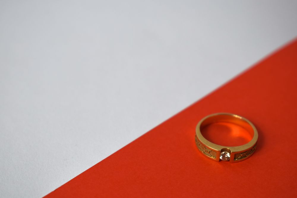 Man's diamond gold ring on duotone background with copy space