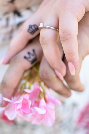Cropped hands of man and woman with matching King and Queen tattoos