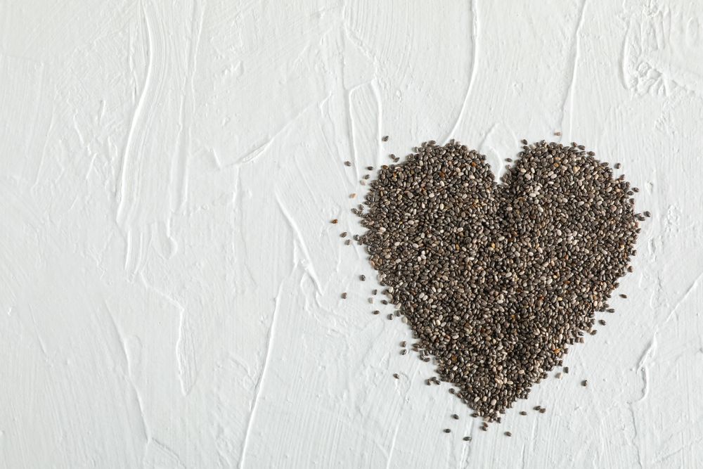 Heart layout of chia on neutral background, copy space