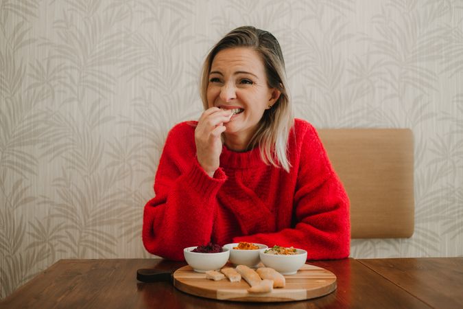 Woman smiling eating assorted food at table