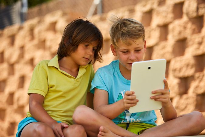 Boys using tablet in garden