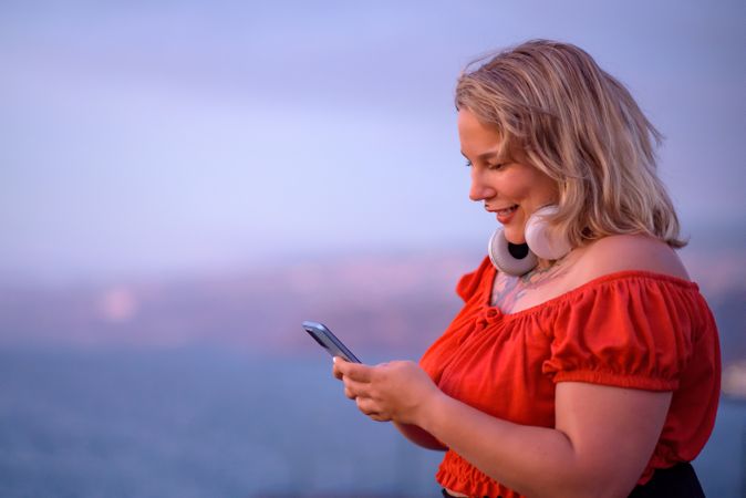 Cheerful body positive woman using smartphone