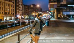 Female runner stretching her legs before training at night in town 0Pjnml