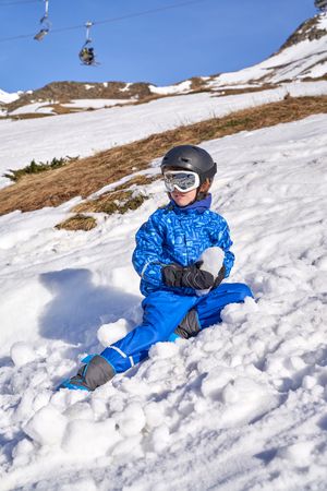 Boy with snow lump in mountains