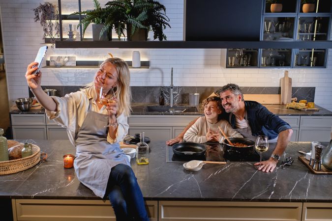 Happy multiracial family taking self portrait in kitchen