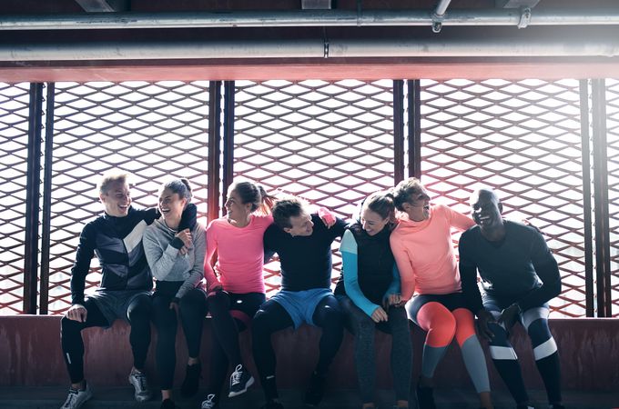 Multi-ethnic group of people in athletic gear sitting together and resting