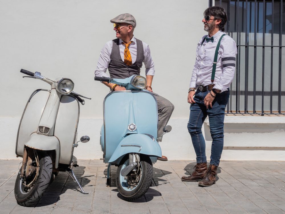 Trendy men sitting on vintage scooters