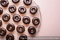 Close up of fresh donuts with melted chocolate set to cool 4j6e94