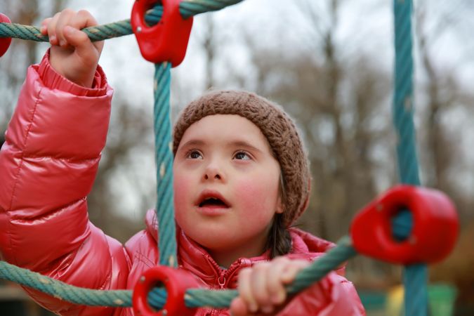 Focused young child climbing on a playset outdoors at a park