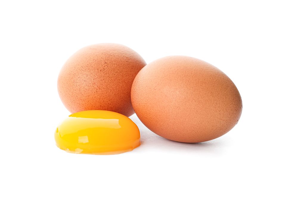 Chicken eggs and egg yolk isolated on blank background