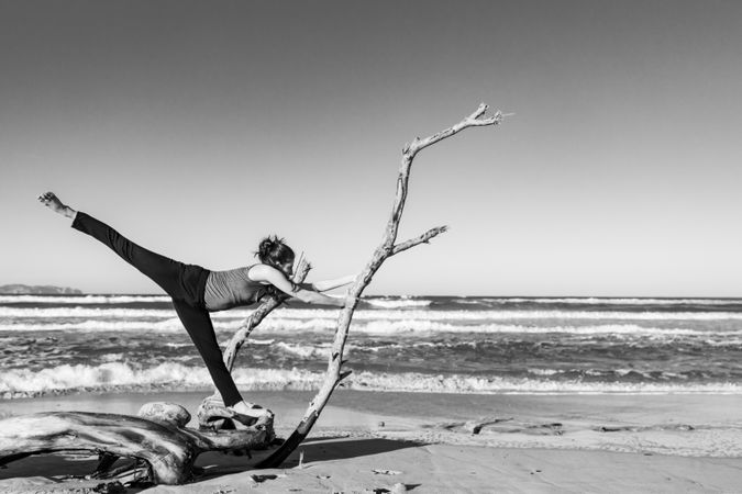 Young woman dancing and posing near water on shore