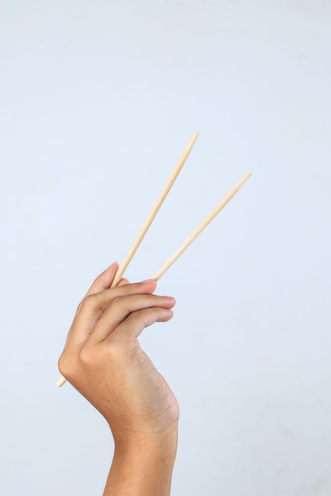 Female Hand Holding Bamboo Chopsticks