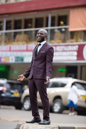Man in suit standing on the road smiling