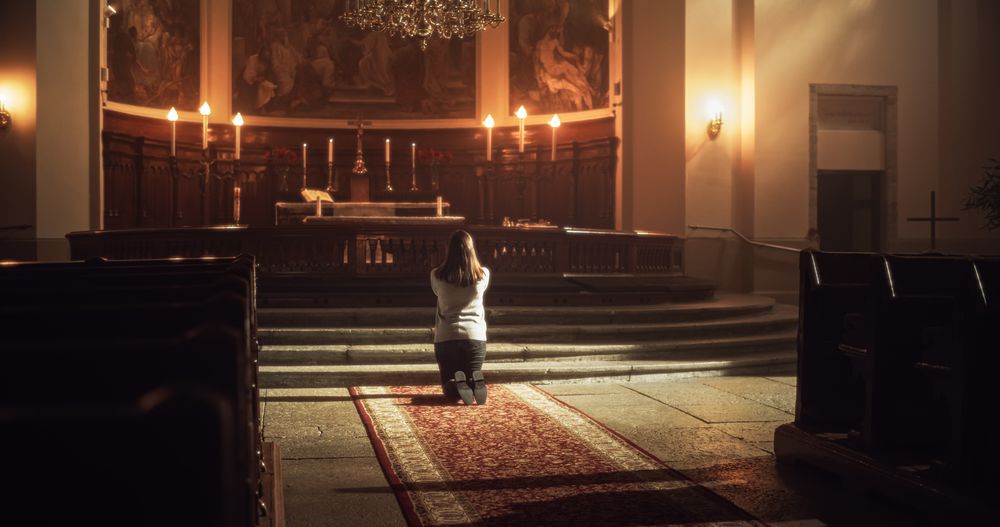 Back View: Christian Woman Getting on her Knees and Starting to Pray in a Church.