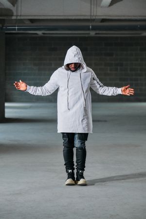 Man standing in garage with arms apart