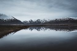 Snowcapped mountains reflected In still lake