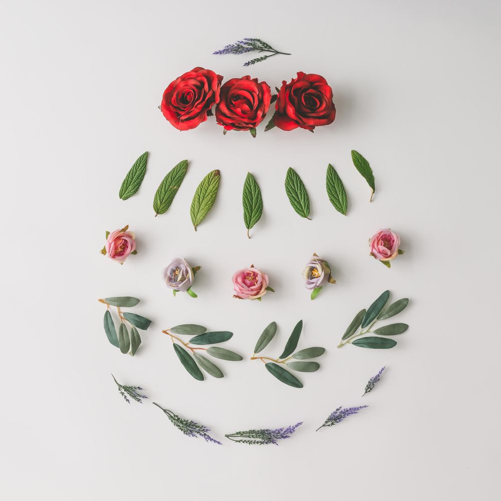 Easter egg shape made of colorful spring flowers and green leaves