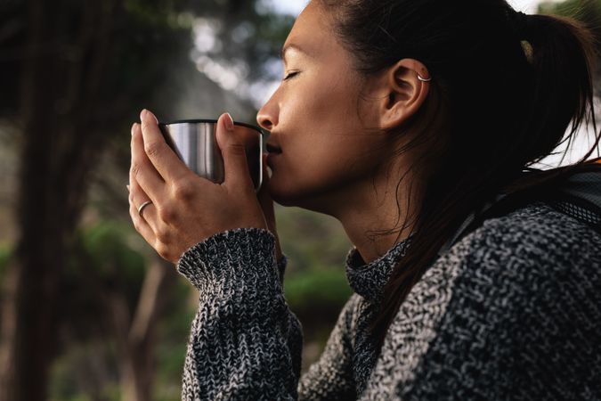 Female hiker taking rest and drinking fresh coffee