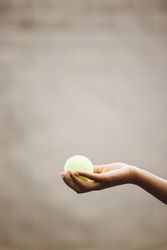 Hand holding a tennis ball