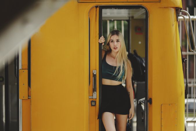 Cheerful blonde woman standing on train in drivers cabin