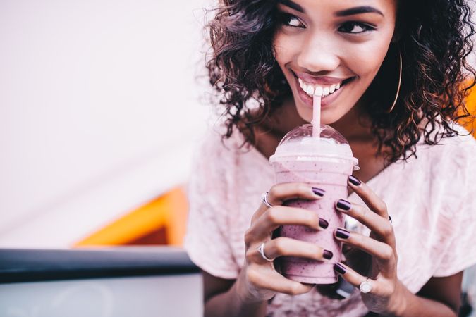 Young woman happily drinking a milk shake