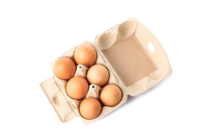Brown chicken eggs in carton box isolated on blank background. top view