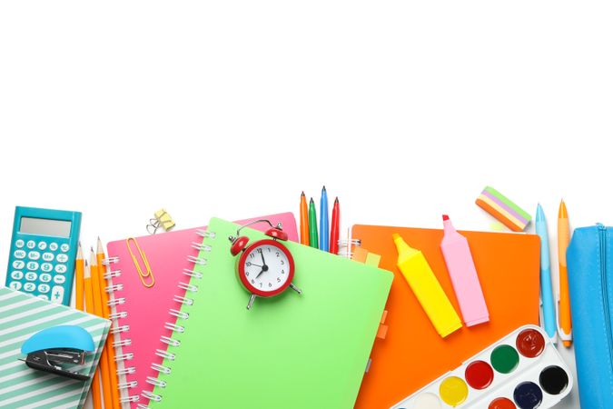 Stationary and art supplies scattered on plain background with copy space