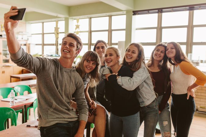 Group of university students making a selfie with smart phone in classroom