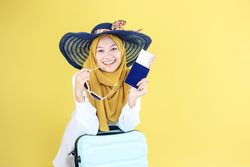 Close Up Happy Asian Muslim Traveler Holding Pasport and Ticket
