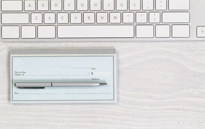 Blank checkbook with pen on desktop