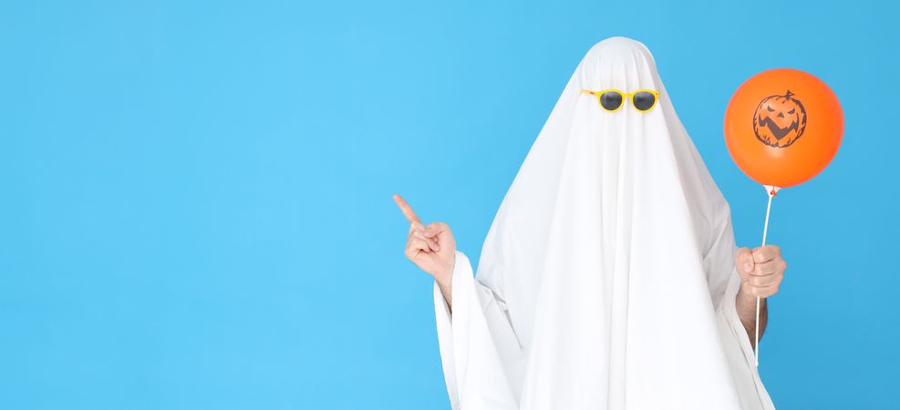 Concept of Halloween, Ghost in sunglasses on blue background