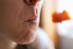 Plant-Powered Living: Woman Eating Carrot for a Radiant, Nutritious Meal.