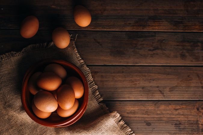 Chicken eggs on napkin on wooden table