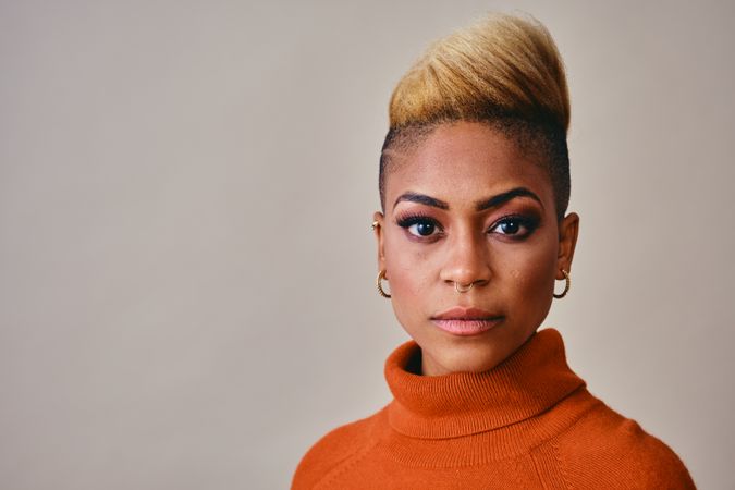 Studio shot of serious Black woman with short blonde hair