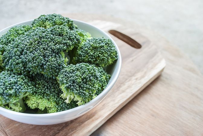 Fresh broccoli vegetable in bowl on wooden table