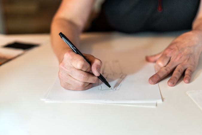 Close-up of a fashion desinger drawing with a pencil.