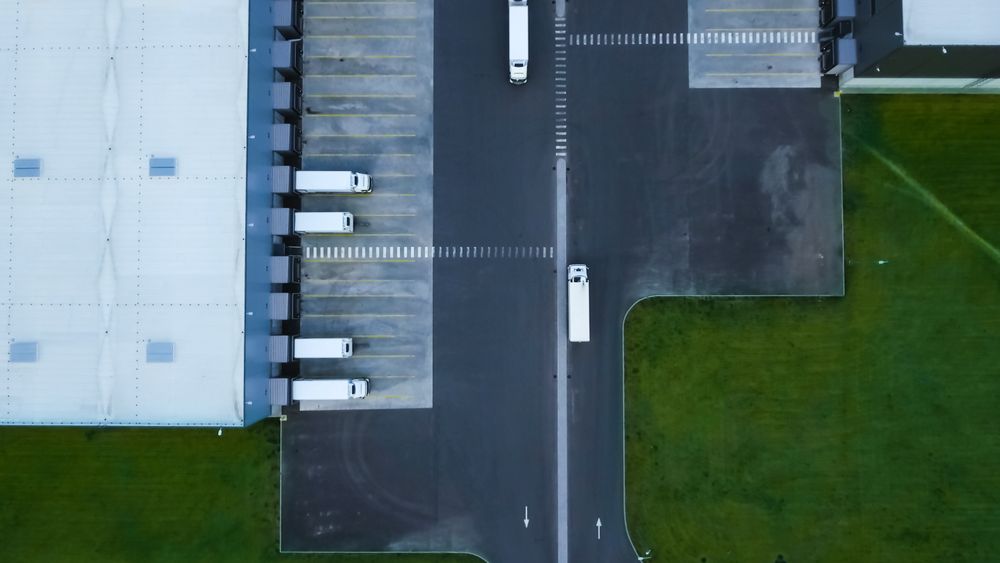 Aerial Perspective of a Dynamic Distribution Center With Trucks Efficiently Navigating Loading Docks
