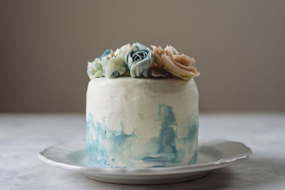 Buttercream flowers cake, blue and pastel peach colors