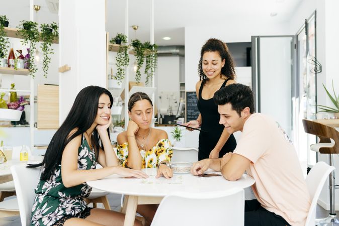 Friends making order in modern cafe