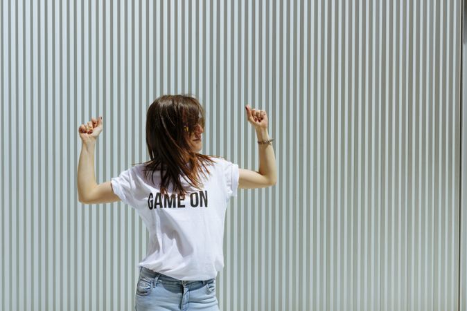 Young woman dancing near wall