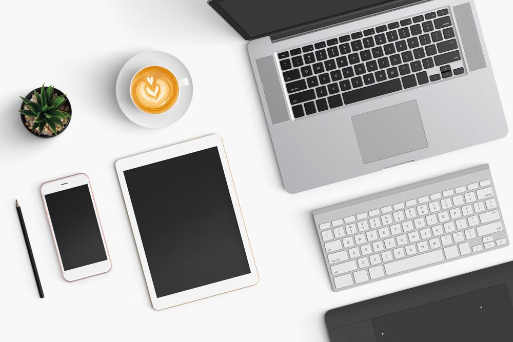 Modern workspace with coffee cup, smartphone, paper, notebook, tablet and laptop