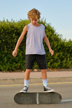 Preteen skater standing on skateboard in city