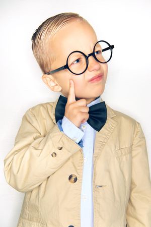 Boy making an inquisitive face wearing round glasses and bow tie