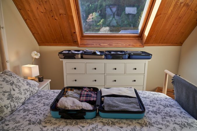 Modern bedroom interior with opened suitcases