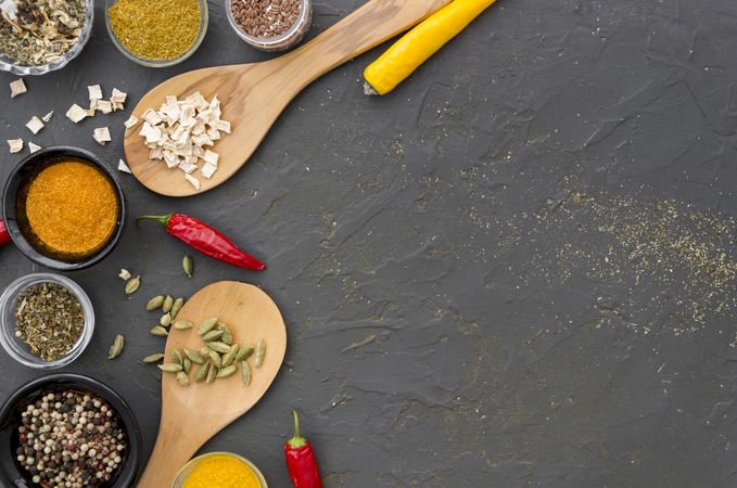 Assorted spices and herbs on grey background with copy space