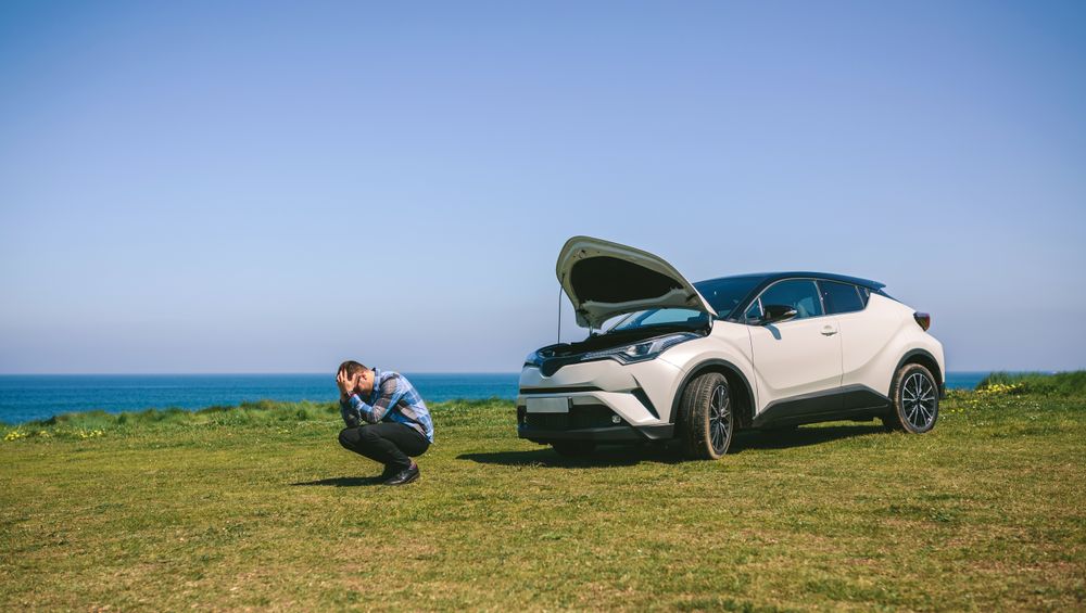 Young man desperate, car broken down