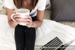 Cropped photo of woman on bed with coffee and laptop 0LzLX4