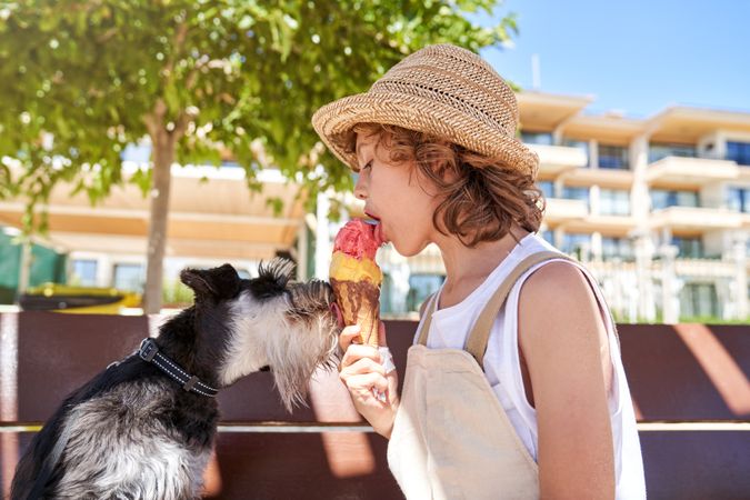Boy eating delicious ice cream with dog